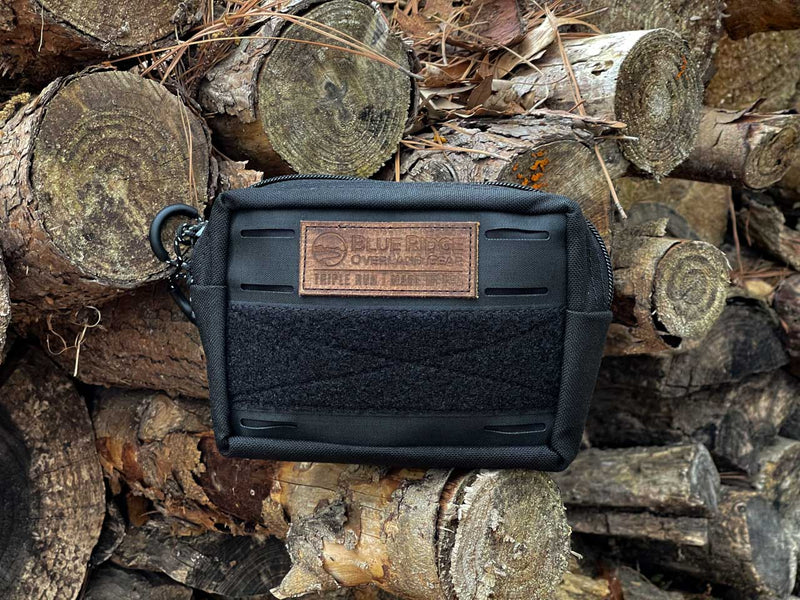 Blue Ridge Overland Gear Bum Bag - black on black, displayed on pile of chopped wood