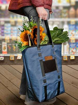 X-Pac Market Tote bag by Blue Ridge Overland Gear - young woman holds high end tote full of groceries and flowers in health food store.
