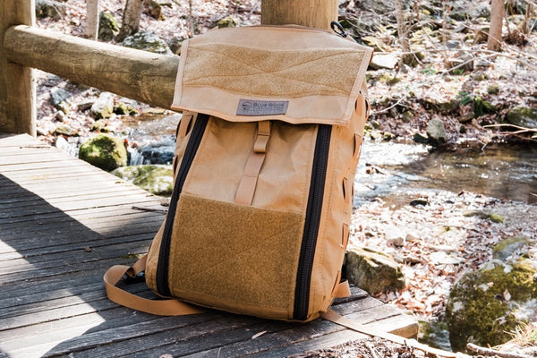 Coyote Brown backpack on a wooden platform with a natural landscape in the background