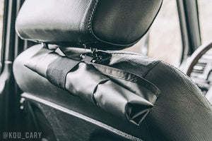 Roll up dump pouch hanging off driver headrest, rolled up for storage.