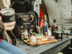 Speakeasy Bourbon Bag by Blue Ridge Overland Gear set up as a portable cocktail bar with whiskey, rum, bar tools, and drink accessories.