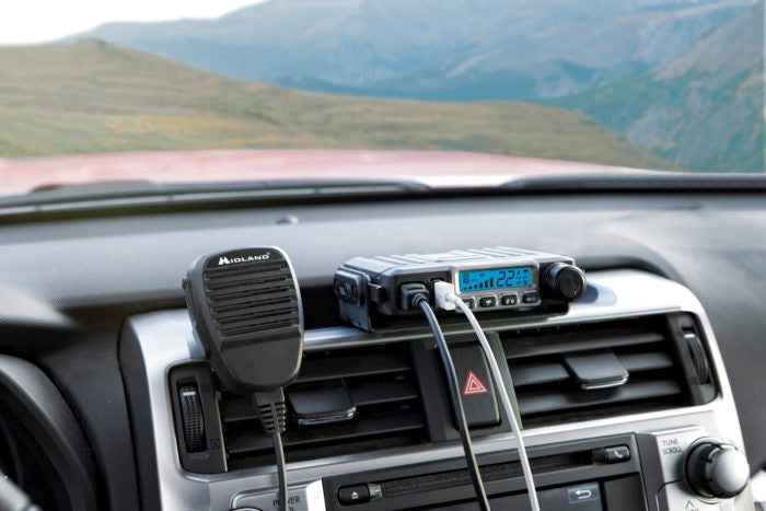 MXT115 15-Watt TWO-WAY GMRS RADIO mounted on a dashboard with an iphone cord plugged into the usb port