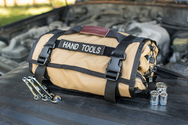 Coyote BROG Tool Pouch Roll labeled “Hand Tools” on a vehicle with wrenches and sockets laid out beside it, ready for vehicle maintenance.